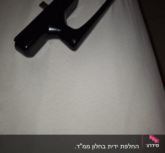 ידית שחורה לתריסים על משטח בהיר